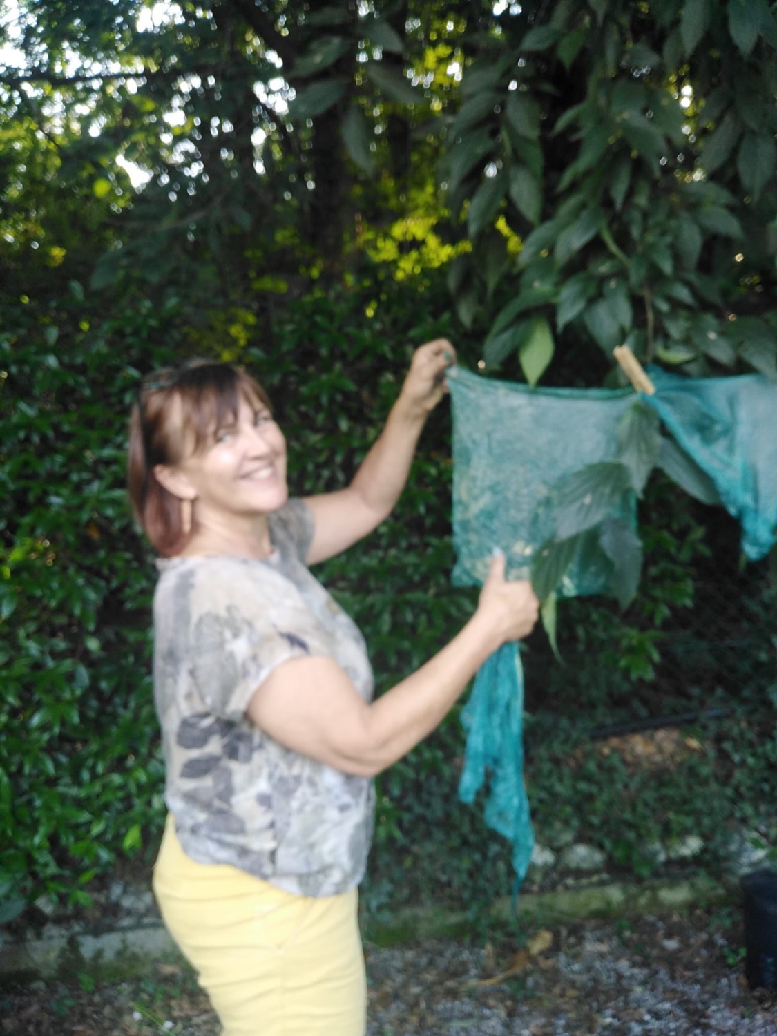 Stesura della seta tinta all'ombra nel giardino dell'atelier di Arco
