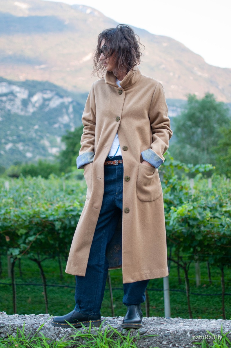 Front, in the vineyard — Pelèr N° II, camel wool and cashmere seven-eighths coat, handmade in the natuRa.Ely atelier in Arco, Lake Garda