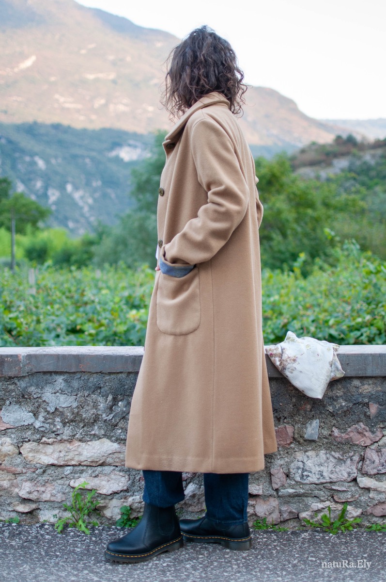 In profile — Pelèr N° II, camel wool and cashmere seven-eighths coat, handmade in the natuRa.Ely atelier in Arco, Lake Garda