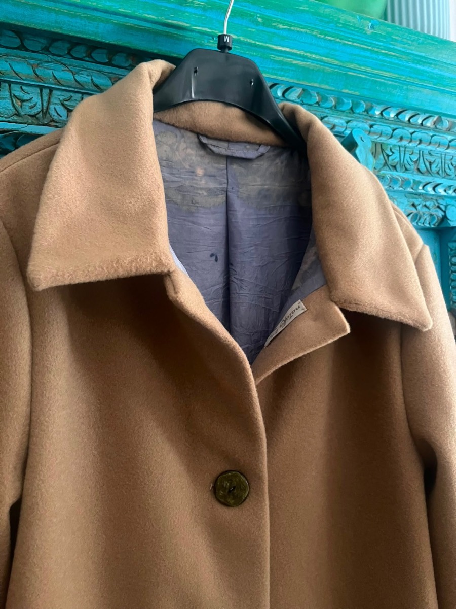 The label, sewn into the collar — Pelèr N° II, camel wool and cashmere seven-eighths coat, handmade in the natuRa.Ely atelier in Arco, Lake Garda
