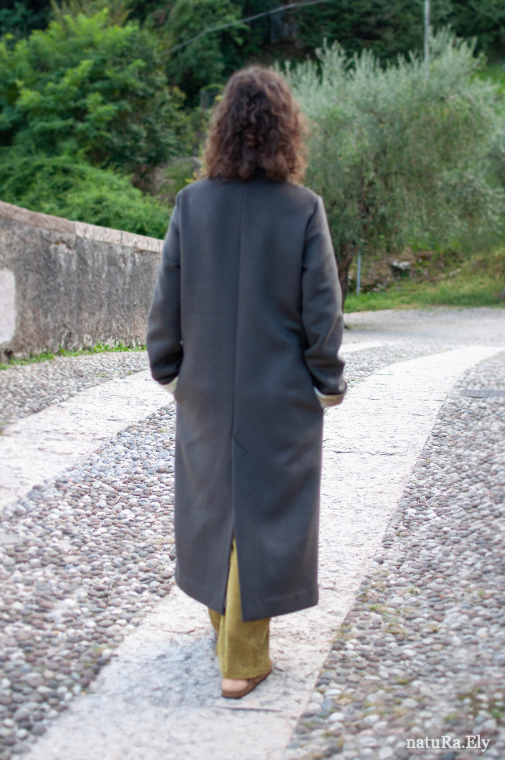 The silk, in movement — Pelèr N° IV, dark taupe wool and cashmere coat with concealed pocket, handmade in the natuRa.Ely atelier in Arco, Lake Garda