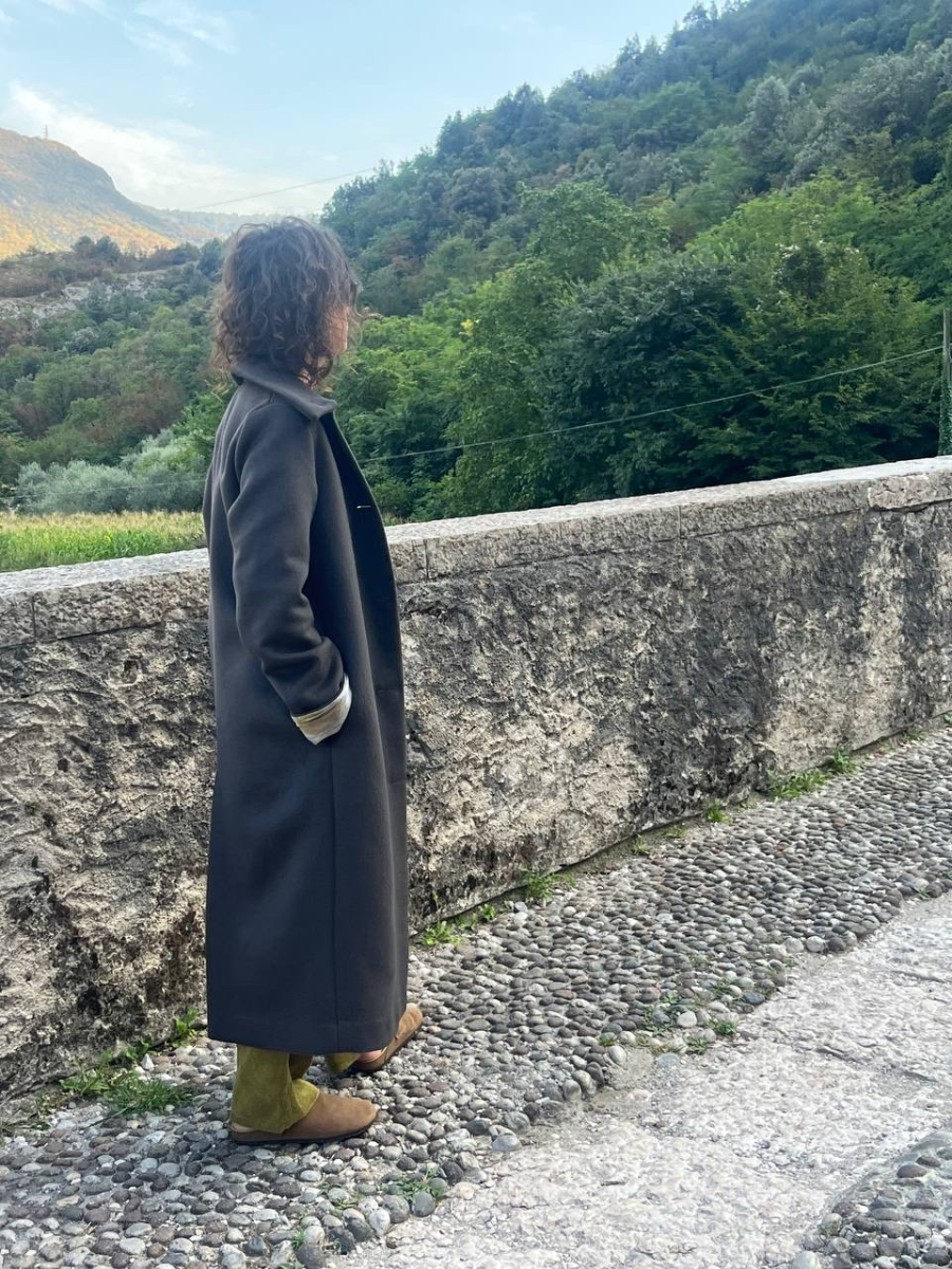 In profile — Pelèr N° IV, dark taupe wool and cashmere coat with concealed pocket, handmade in the natuRa.Ely atelier in Arco, Lake Garda