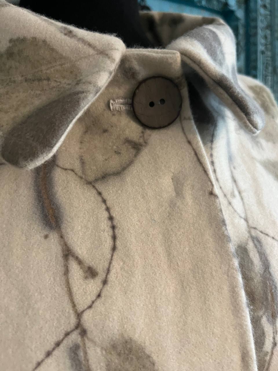 The coconut button at the collar, with its hand-embroidered buttonhole