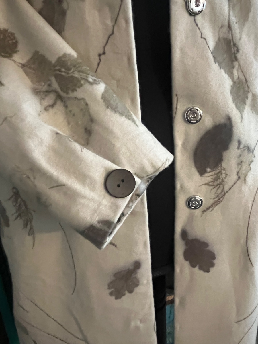 The gathered sleeve closed with a coconut button, beside the press studs